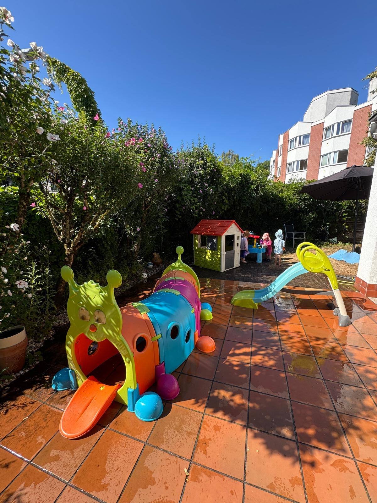 Garten mit Spielhaus, Krabbeltunnel und Rutsche auf der Terrasse